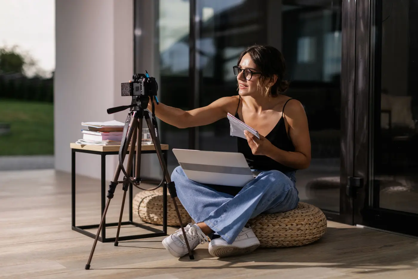 A professional preparing a camera and laptop for an online learning session
