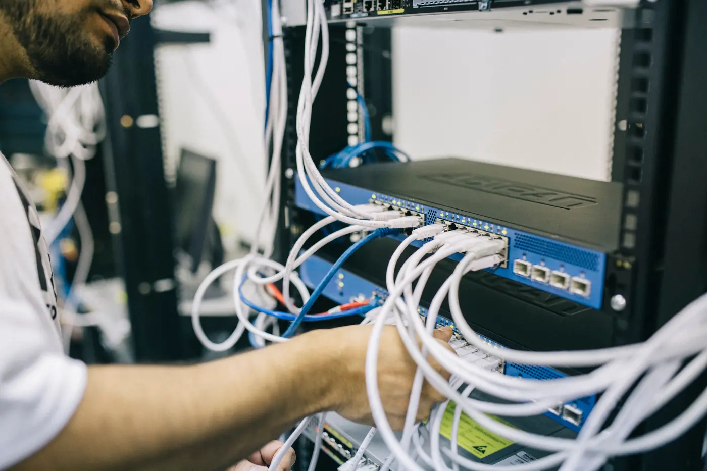 An engineer working with network connections in a server rack